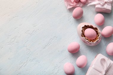 Mavi grunge arka planda hediye kutularıyla boyanmış Paskalya yumurtaları.