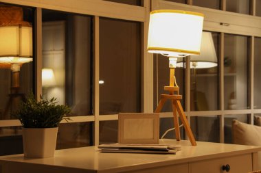 Geceleri yatak odasındaki çerçeveli ve dergileri olan parlayan lamba.