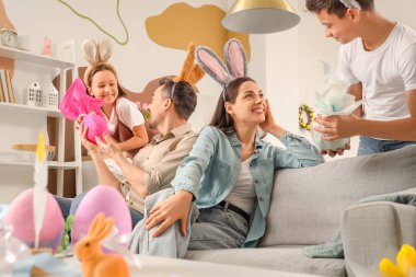 Mutlu ebeveynler, Paskalya Günü 'nde küçük çocuklarından hediye yumurtaları alıyorlar.