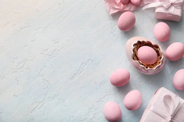 Mavi grunge arka planda hediye kutularıyla boyanmış Paskalya yumurtaları.