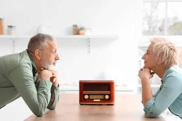 Mature couple listening to radio in kitchen