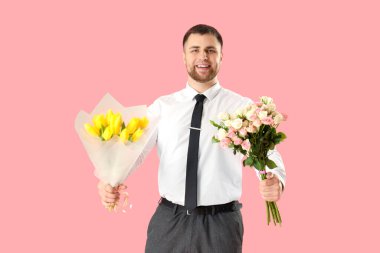 Pembe arka planda çiçekli yakışıklı bir adam.