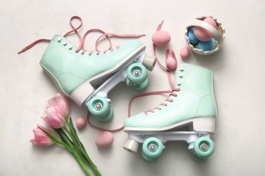 Paskalya yumurtası sepeti ve beyaz arka planda güzel laleleri olan klasik patenler.