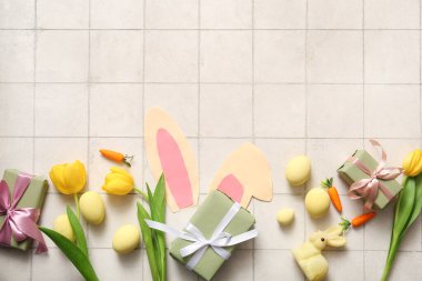 Paskalya yumurtalı kağıttan tavşan kulakları, lale çiçekleri ve beyaz kartonlu hediye kutuları.