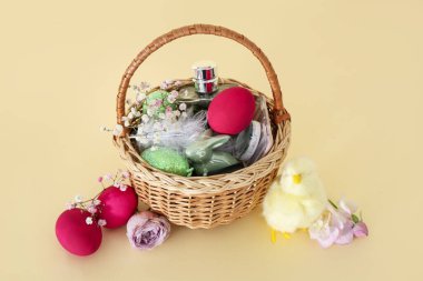 Süslü kozmetik sepetleri, Paskalya yumurtaları ve sarı arka planda bebek tavukları.