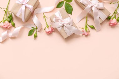 Bej arka planda gül çiçekleriyle süslenmiş kutlama paketleriName