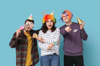 Mavi arka plandaki izleyiciye bakan kağıt balıklarıyla komik kılık değiştirmiş genç arkadaşlar. 1 Nisan kutlamaları