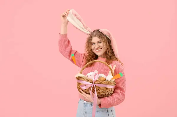 Piękna Młoda Szczęśliwa Kobieta Króliczych Uszach Koszykiem Wielkanocnym Różowym Tle — Zdjęcie stockowe
