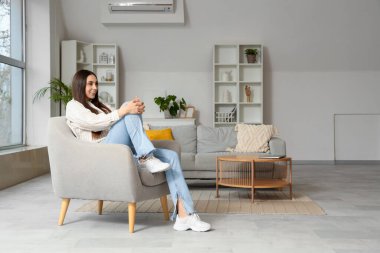 Evdeki koltukta oturan güzel kadın.