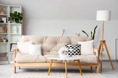 Konforlu kanepe ve beyaz mobilyalarla aydınlık oturma odasının içinde.