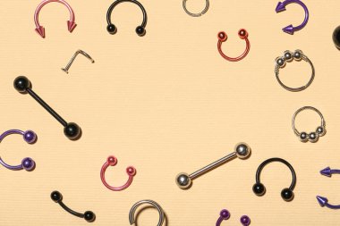 Renk arkaplanındaki piercing için süslü mücevherlerden yapılmış çerçeve