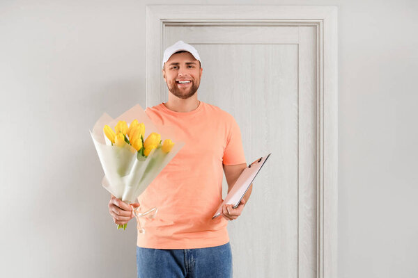 Male courier with flowers near door