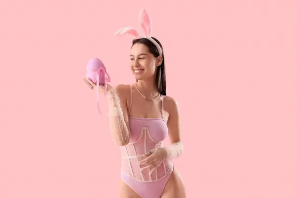 粉红背景的带复活节彩蛋的兔子耳朵性感年轻女人 — 图库照片