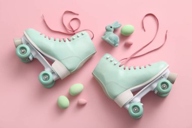 Paskalya yumurtaları ve pembe arka planda oyuncak tavşanla klasik patenler.