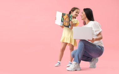 Çalışan anne ve pembe arkaplan üzerine kitabı olan küçük kızı.