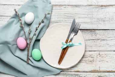 Paskalya için çok güzel bir sofra. Yumurtalar ve söğüt dalları açık ahşap arka planda.