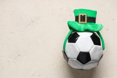 Beyaz grunge arka planında cüce şapkası olan futbol topu. Aziz Patrick Günü kutlaması