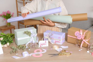 Ambalaj kağıtları ve güzel hediye kutuları olan bir kadın. Uluslararası Kadınlar Günü
