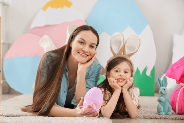 Genç anne ve küçük kızı evde Paskalya hediyesi yumurtasıyla