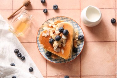 Kalp şeklinde leziz krepler, bej kaplamalı yabanmersini, fındık ve süt tabağı. Sevgililer Günü kutlaması