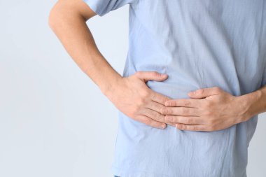 Genç adam arka planda yan ağrıdan muzdarip.