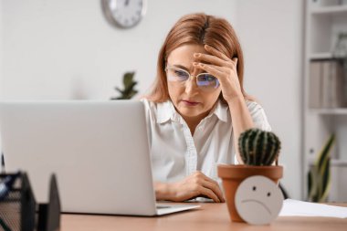 Ofiste oturan basur hastası, olgun bir iş kadını.