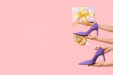 Hediye kutusu olan kadın elleri, yüksek topuklu ayakkabılar ve pembe arka planda balon. Uluslararası Kadınlar Günü için Alışveriş