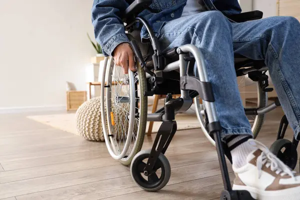 Evdeki tekerlekli sandalyedeki genç adam, yakın plan.