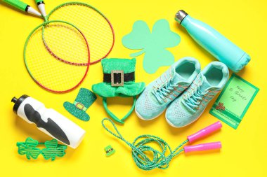 Sarı arka planda Aziz Patrick Günü kutlamaları için spor malzemeleri ve dekorasyonlar