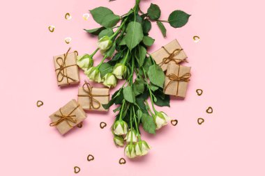 Pembe arka planda hediyeleri olan güzel güller