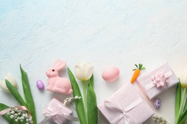 Çiçekli Paskalya yumurtaları ve mavi grunge arka planda hediye kutuları.