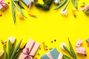 Hediye kutularıyla lale çiçekleri ve sarı arka planda Paskalya tavşanları.