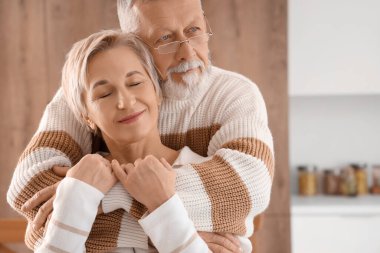 Olgun çift mutfakta sarılıyor, yakın çekim.