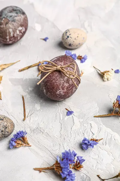 Paskalya yumurtaları ve grunge gri arka planda güzel çiçekler.