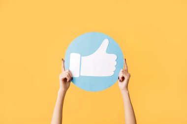 Turuncu arka planda ikon gibi duran kadın eller