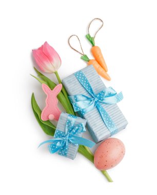 Paskalya yumurtası, kumaş tavşanı, lale ve beyaz arka planda hediyeler