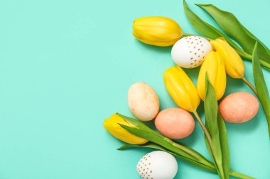 Turkuaz arka planda güzel lale çiçekleriyle boyanmış Paskalya yumurtaları.