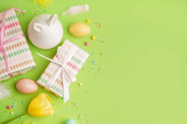 Paskalya hediyeleri, yeşil arka planda boyanmış yumurtalar ve tavşan figürü.