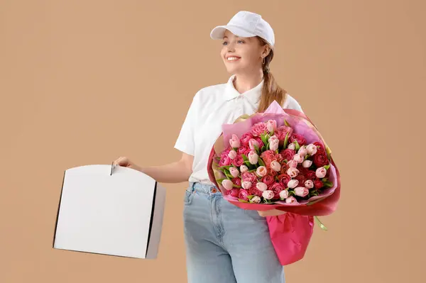 Female courier with bouquet of flowers and box on brown background