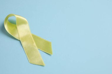 Mavi arka planda altın kurdele. Çocukluk kanseri farkındalığı