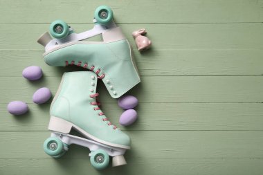 Paskalya yumurtaları ve yeşil ahşap arka planda oyuncak tavşanlı klasik patenler.