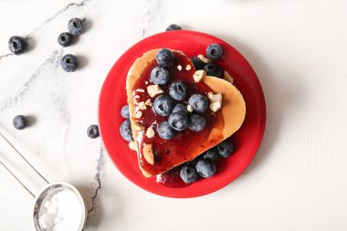 Kalp şeklinde lezzetli krepler, hafif arkaplanda yaban mersini ve reçel. Sevgililer Günü kutlaması