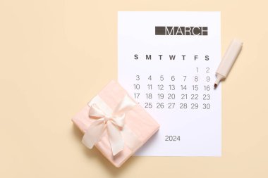 Bej arka planda takvim ve hediye kutusu. Uluslararası Kadınlar Günü