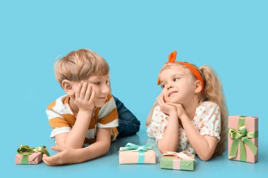 Mavi arka planda hediye kutuları olan şirin çocuklar. Uluslararası Kadınlar Günü