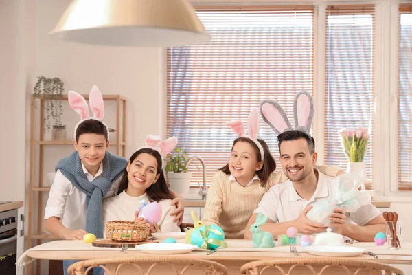 Paskalya günü yemek odasında yumurtalı mutlu bir aile.