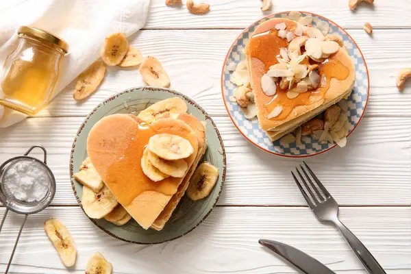 Kalp şeklinde lezzetli gözleme tabakları, fındık ve açık ahşap zemin üzerinde kurumuş muz. Sevgililer Günü kutlaması