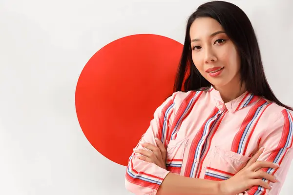 Young Asian woman against flag of Japan, closeup