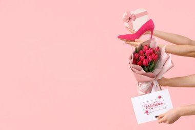 Lale buketi, hediye kutusu ve pembe arka planda bayram kartpostalı olan kadın elleri. Uluslararası Kadınlar Günü için Alışveriş