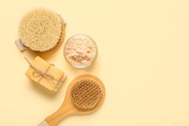 Açık sarı arka planda sabun ve fırçalarla fırçala. Vücut masajı konsepti