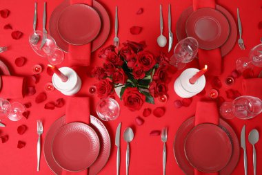 Sevgililer Günü kutlaması için yemek masası, mumlar ve kırmızı güller.